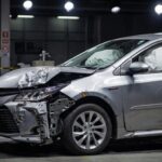 Toyota vehicle showing severe front-end damage in crash test safety evaluation