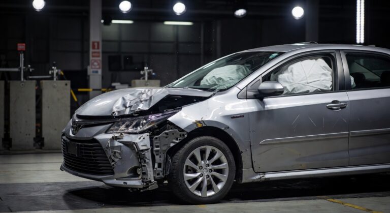 Toyota vehicle showing severe front-end damage in crash test safety evaluation