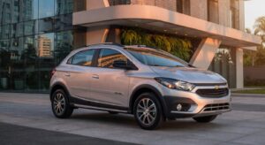 Chevrolet Onix Activ 2027 em ambiente urbano moderno, vista frontal três quartos