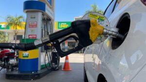 Close-up of fuel pump nozzle filling a vehicle tank at a gas station, representing ethanol-gasoline blend fuel