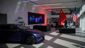 BYD electric vehicle in showroom with Chinese and American flags representing US-China geopolitical tensions