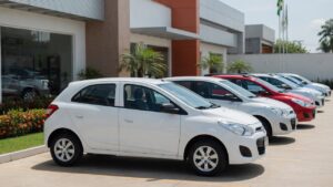 Carros econômicos populares alinhados em concessionária brasileira, representando os veículos mais baratos de manter em 2026
