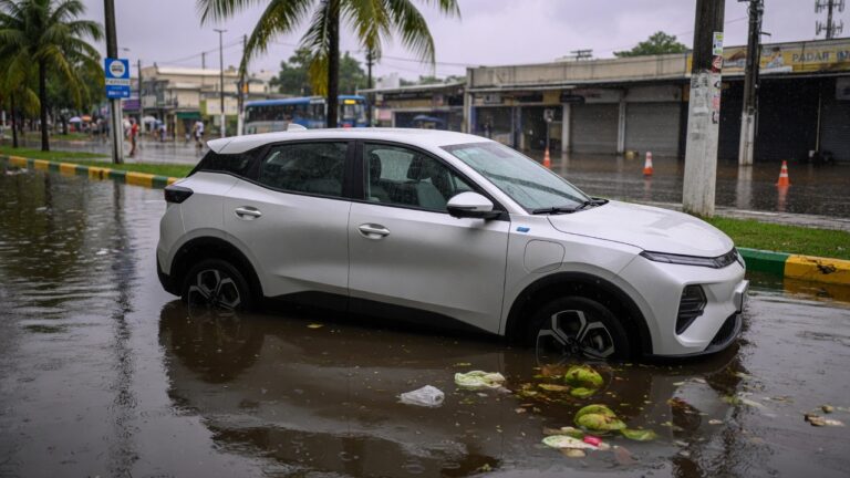 Carro elétrico parcialmente submerso em enchente urbana com água atingindo as portas do veículo
