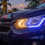 Close-up view of modern car with LED headlights illuminated, representing the LED headlight regulation debate in Brazil
