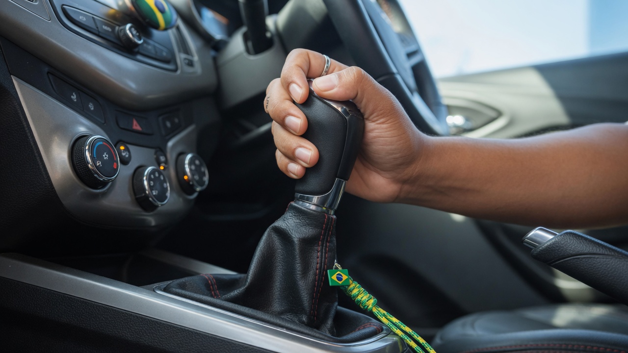 Mão de motorista trocando marcha em câmbio manual de carro, representando a coordenação motora e estímulo cerebral da condução com transmissão manual