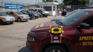 Veículo apreendido em pátio oficial com dispositivo de rastreamento eletrônico instalado, representando o novo sistema de monitoramento e leilão virtual de automóveis