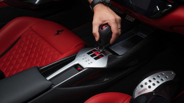 Interior detalhado da Ferrari 12Cilindri mostrando alavanca de câmbio manual e pedal de embreagem em close profissional