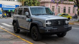 GWM Tank 300 SUV híbrido plug-in estacionado em ambiente urbano brasileiro, vista frontal em três quartos destacando design moderno e porta de carregamento