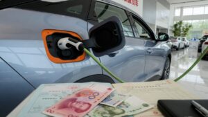 Carro híbrido em concessionária chinesa com documentos fiscais representando o fim da isenção de impostos para veículos híbridos na China