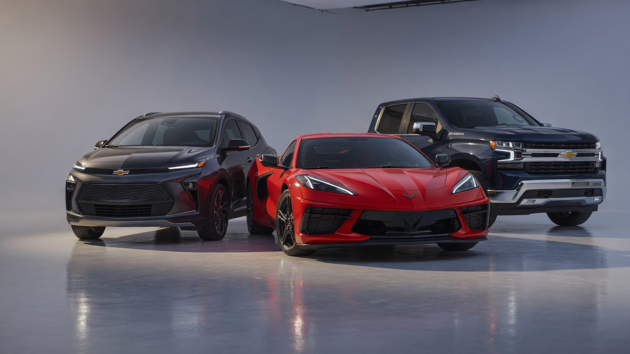 Três veículos Chevrolet modernos lado a lado em estúdio automotivo profissional representando parcerias tecnológicas da marca
